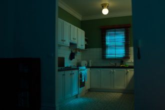 A scale model of a suburban kitchen photographed with blue and green light